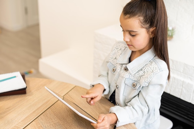 Menschen, Kinder und Bildungskonzept - Mädchen mit Tablet-PC-Computer, der zu Hause schreibt