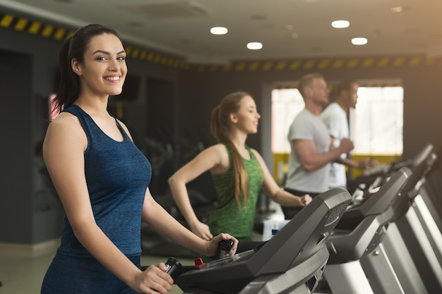 Menschen laufen auf Laufbändern. Cardio-Training für Männer und Frauen im Fitnessclub. Gesunder Lebensstil, Training im Fitnessstudio, Kopienraum