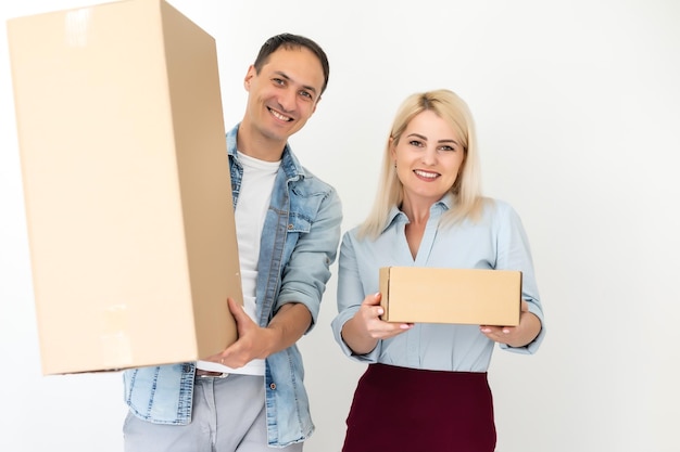 menschen, lieferung, versand und postdienstkonzept - glückliches paar, das zu hause karton oder paket öffnet