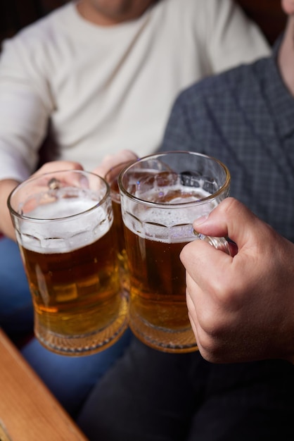 Menschen Männer Freizeit Freundschaft und Feier Konzept glückliche männliche Freunde trinken Bier und klirren