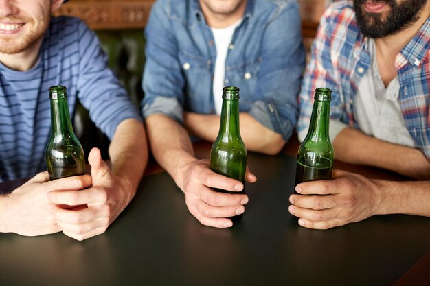 Foto menschen, männer, freizeit, freundschaft und kommunikationskonzept - gruppe glücklicher männlicher freunde, die bier in der bar oder im pub trinken