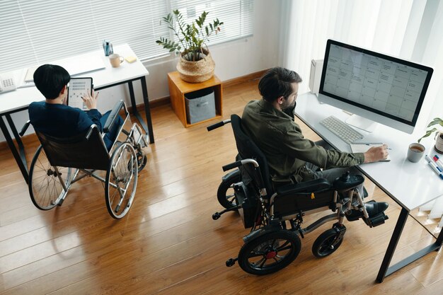Menschen mit Behinderungen, die an Computern arbeiten