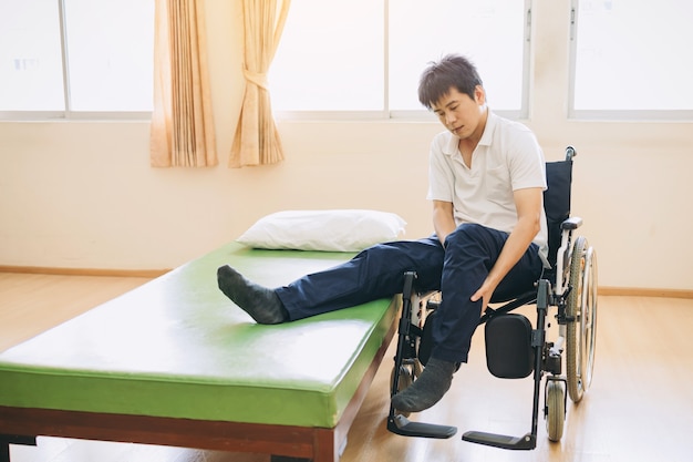 Menschen mit Behinderungen steigen vom Bett in den Rollstuhl um