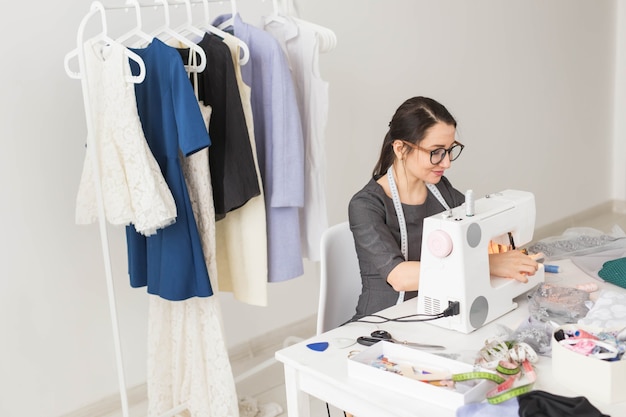 Menschen, Schneiderin, Schneiderin, Mode- und Showroomkonzept - junge Modedesignerin in ihrem Showroom.