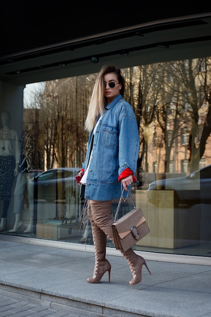 Menschen, Schönheit, Mode, Lifestyle und Farbkonzept - schöne junge Frau mit Knie. Streetstyle-Porträt eines stilvollen Mädchens mit langem, geradem Braun hören hessische Stiefel.