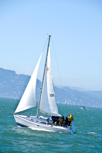 Menschen segeln auf einem Segelboot im Meer gegen den Himmel