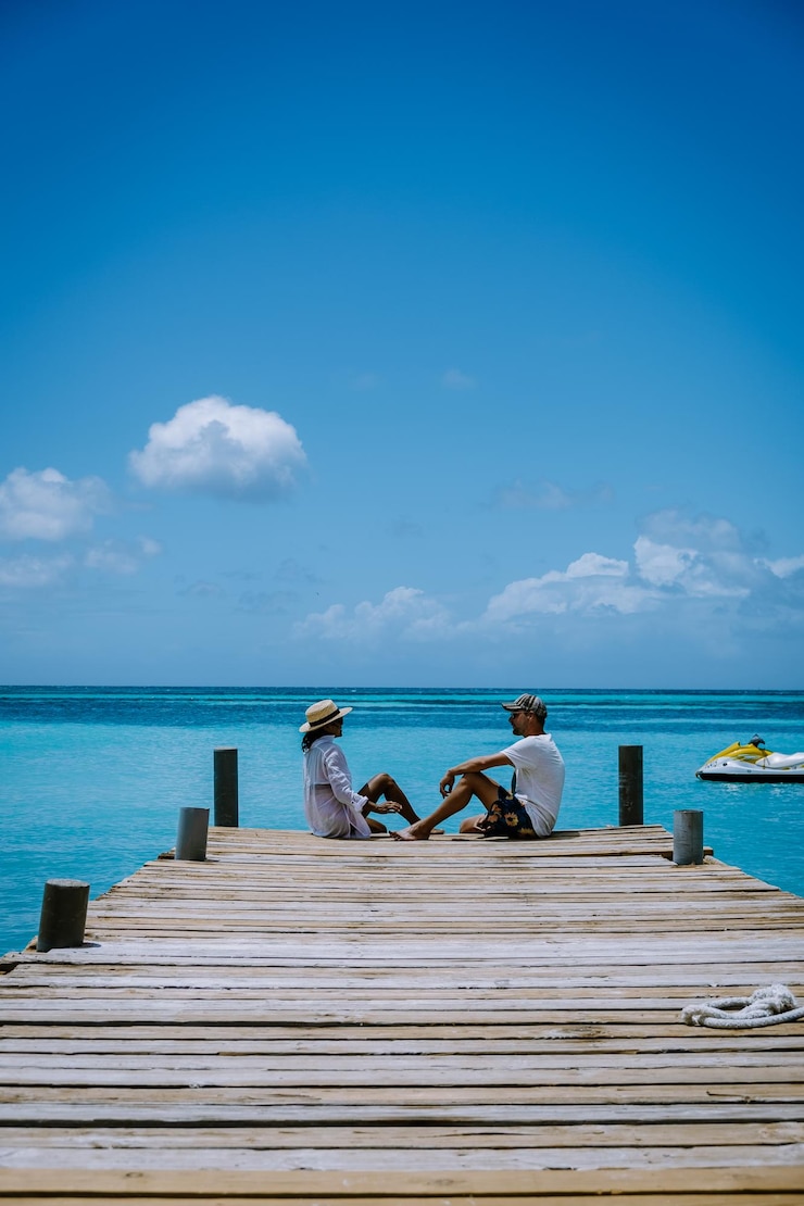 Foto menschen sitzen am pier am meer gegen den blauen himmel