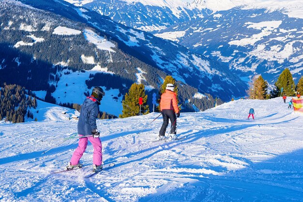 Menschen Skifahrer Skifahren im Skigebiet Penken Park in Tirol in Mayrhofen im Zillertal in Österreich in den Winteralpen. Männer fahren alpine Berge mit weißem Schnee und blauem Himmel Ski. Österreichische schneebedeckte Hänge.