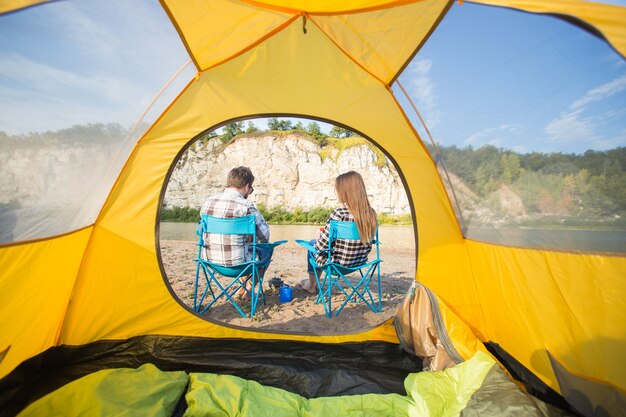 Menschen, Sommertourismus und Naturkonzept - junges Paar ruht in der Nähe von Campingzelt.