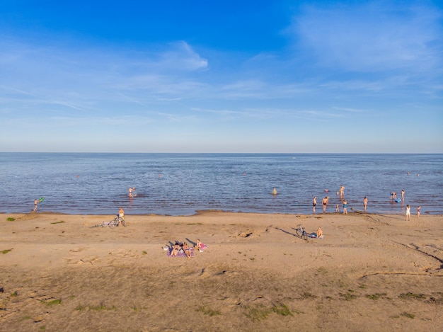 Menschen sonnen sich und schwimmen im See. Vogelperspektive.