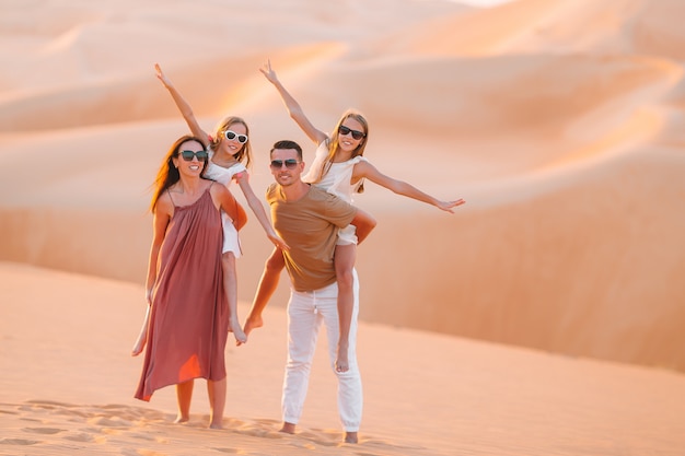 Menschen unter Dünen in der Wüste Rub al-Khali in den Vereinigten Arabischen Emiraten