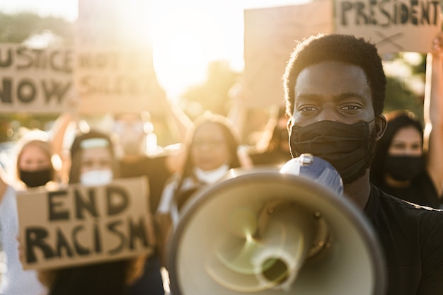 Menschen unterschiedlicher Kulturen und Rassen protestieren auf der Straße für Gleichberechtigung - Demonstranten, die während der Kampfkampagne gegen schwarze Leben Gesichtsmasken tragen - Fokus auf Augen schwarzer Männer