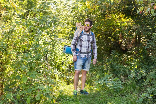 Menschen, Wanderung, Tourismus und Naturkonzept - Mann mit seiner Katze im Wald