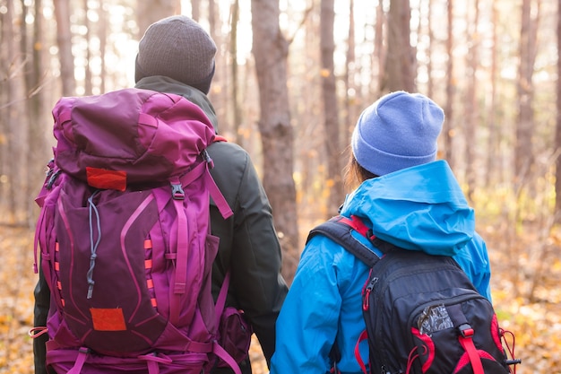 Menschen, Wanderung, Tourismus und Naturkonzept - Paartouristenwandern im Herbstwald, Rückansicht