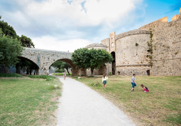 Menschen zu Fuß rund um die Mauern der mittelalterlichen Burg in der Altstadt der Insel Rhodos Griechenland