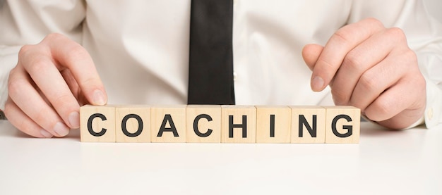 Menschengemachtes Wort COACHING mit Holzblöcken