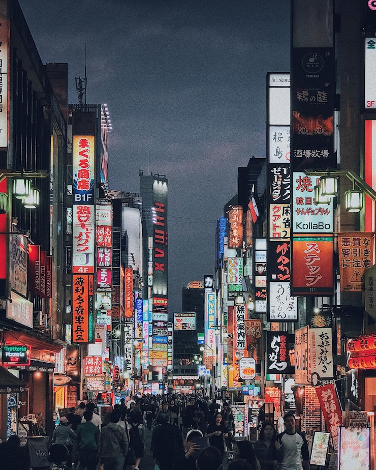 Foto menschenmenge inmitten von beleuchteten schildern in der stadt bei nacht