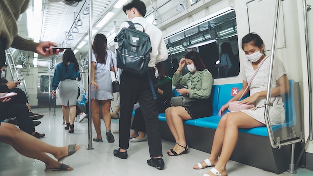 Menschenmenge mit gesichtsmaske auf einer überfüllten öffentlichen u-bahnfahrt