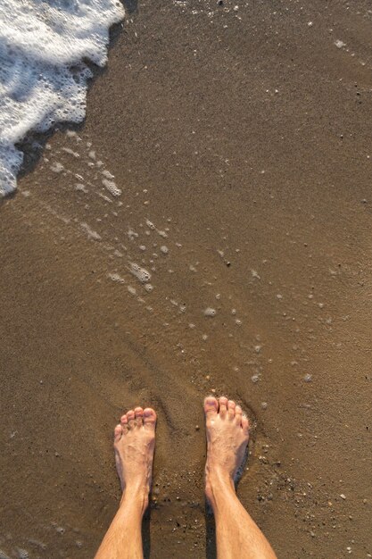 Menschliche barfüßige Füße im nassen Sand am Meeresufer aktives gesundes Wohnkonzept