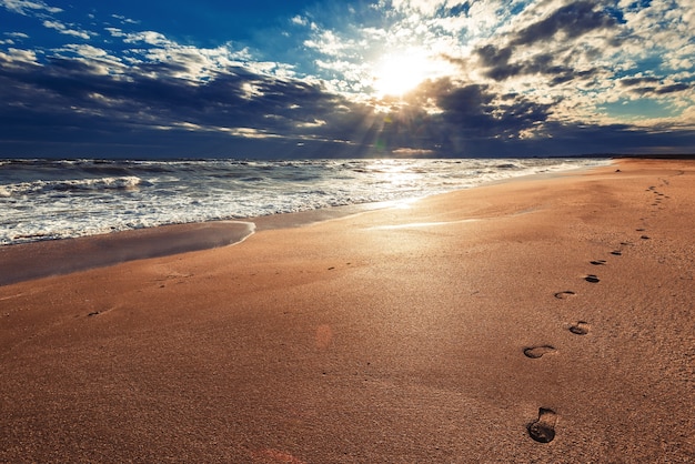 Menschliche Fußabdrücke an einem leeren Meeresstrand