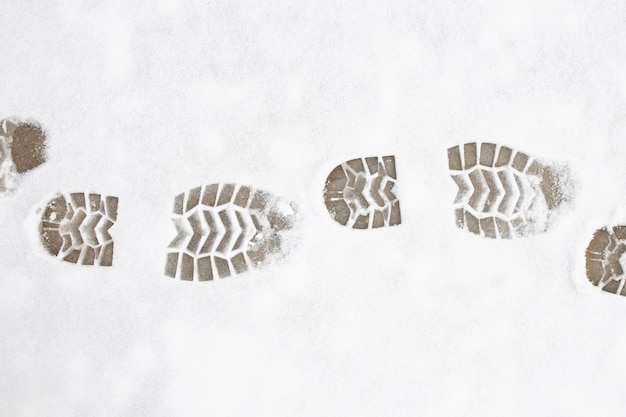 Menschliche Fußabdrücke im Schnee unter Sonnenlicht Nahaufnahme