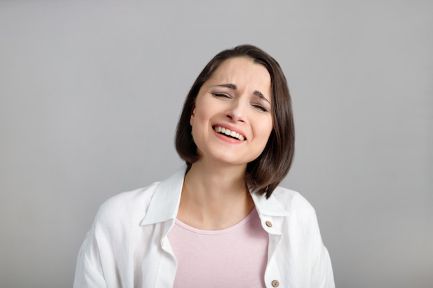 Menschliche Gesichtsausdrücke und Emotionen Porträt einer lachenden jungen brünetten multiethnischen Frau in Pink