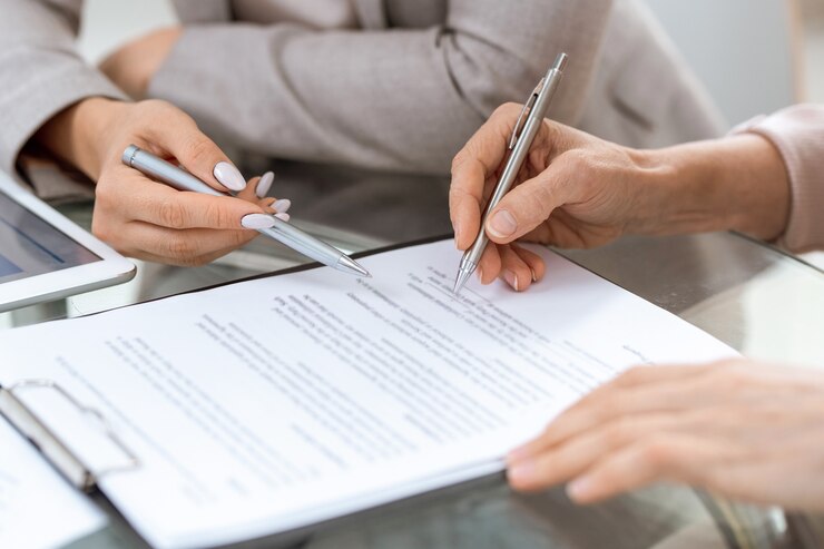 Foto menschliche hände mit stiften über finanzdokument im moment der unterschrift nach erörterung seiner punkte