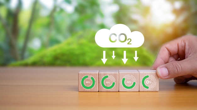 Menschliche Hände wählen Kohlenstofffreie Holzblöcke aus, die das Konzept der Reduzierung von CO2 repräsentieren.