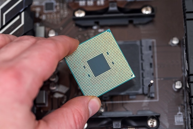 Menschliche Hand, die CPU vom Motherboard herausnimmt