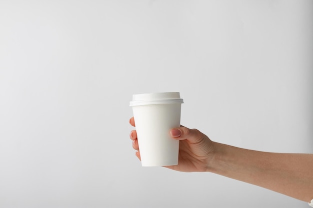 Menschliche Hand, die eine Kaffeetasse hält