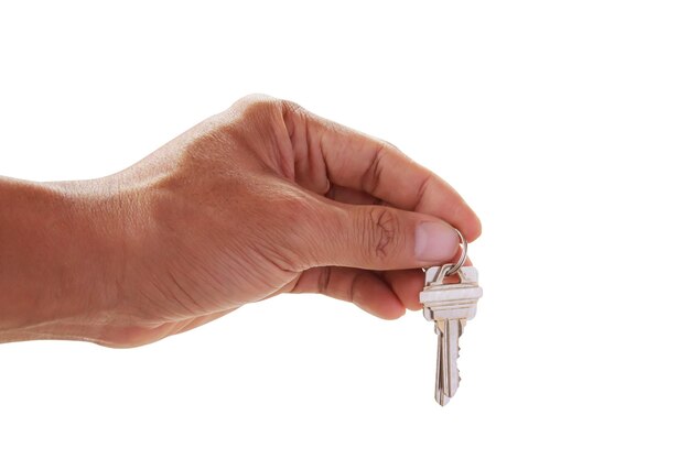 Menschliche Hand, die Schlüssel zu einem Traumhaus hält, das auf Weiß lokalisiert wird