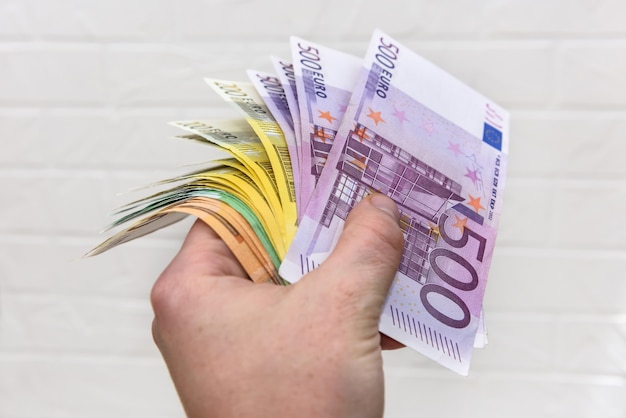 Menschliche Hand mit Euro-Banknoten hautnah