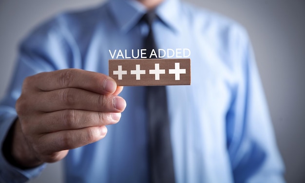 Menschliche Hand zeigt Plus-Symbole mit einem Wort Value Added Profit Benefit Business