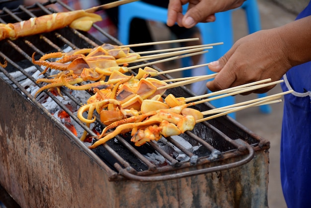 menschliche weibliche hand grillen tintenfisch