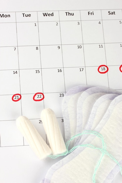 Menstruationskalender mit Damenbinden und Tampons in der Nähe