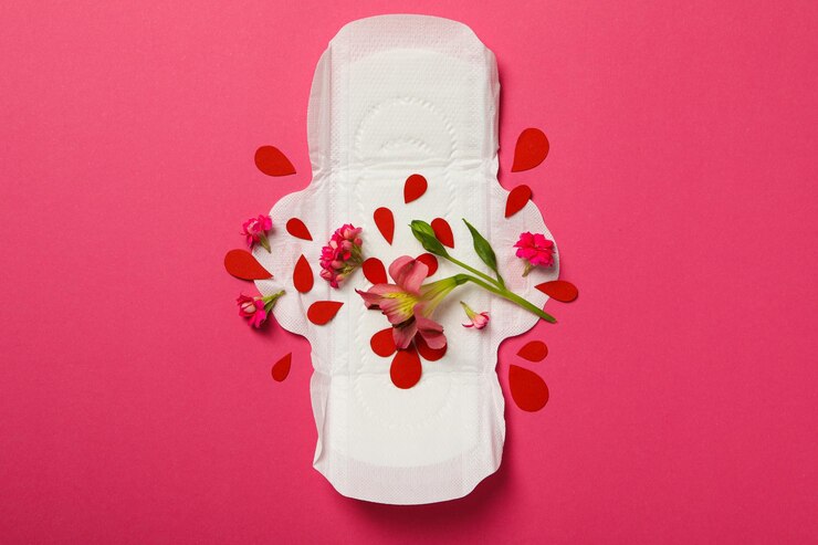 Menstruationskissen mit Blumen auf rosa Hintergrund