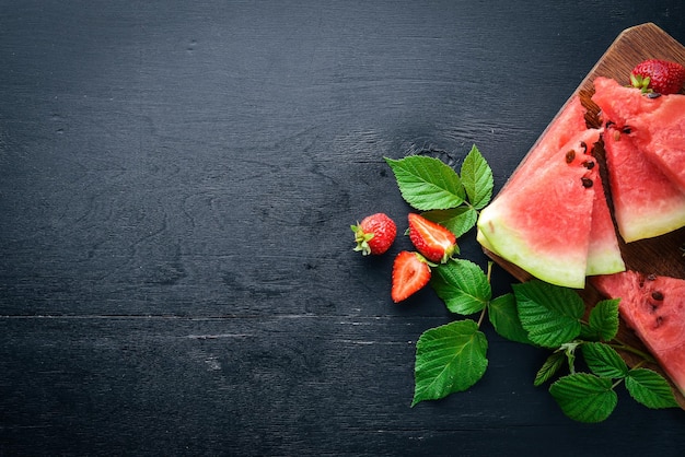 Menta de fresas de sandía En una tabla de madera Rebanada de frutas Vista superior Espacio libre para su texto