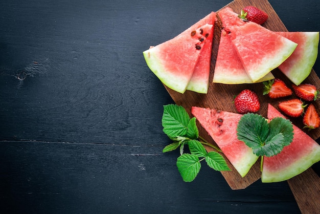 Menta de fresas de sandía En una tabla de madera Rebanada de frutas Vista superior Espacio libre para su texto