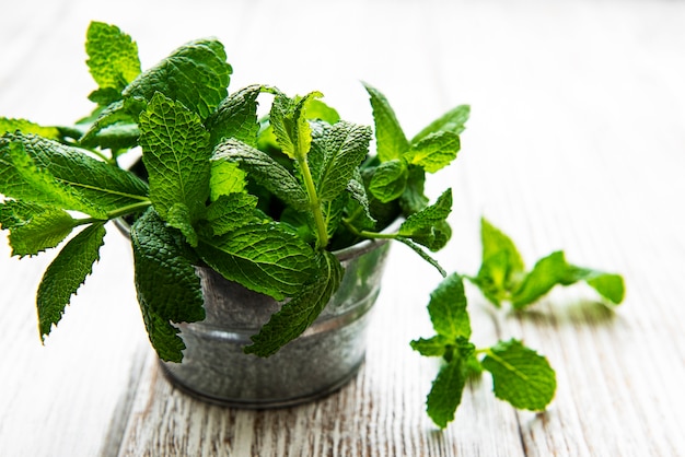 Menta fresca en balde sobre mesa