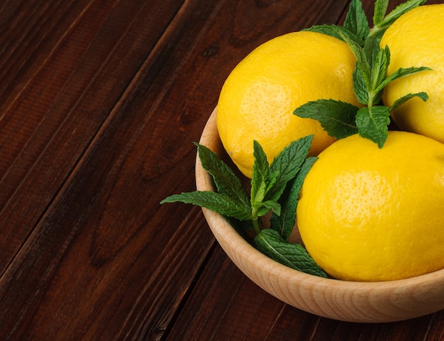Menta fresca y limones enteros en un tazón
