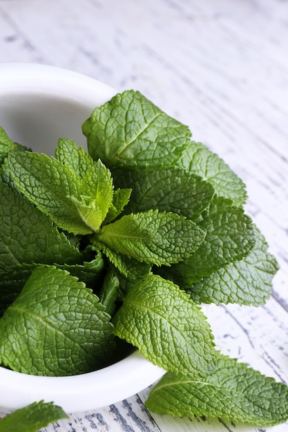 Menta verde fresca em argamassa na cor de madeira