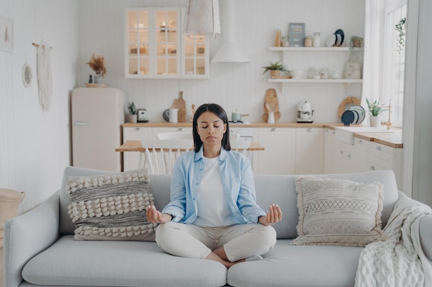 Foto mente pacífica zen y concentración la joven hispana practica yoga en casa