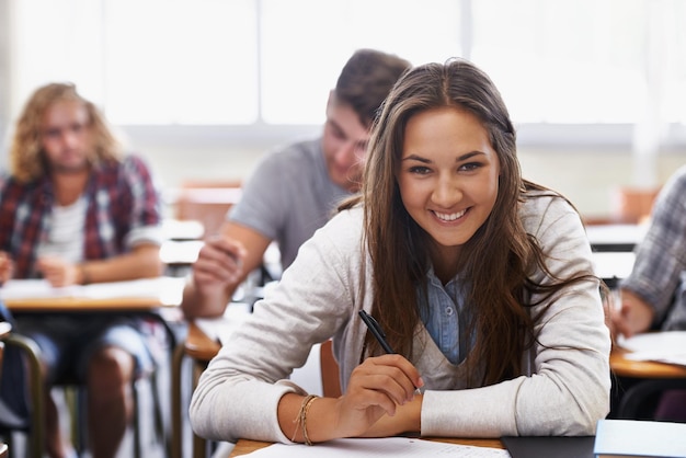 Mentes jóvenes brillantes del mañana Estudiantes jóvenes positivos en un aula universitaria