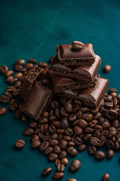 Mentira de chocolate escura sobre um fundo escuro com grãos de café