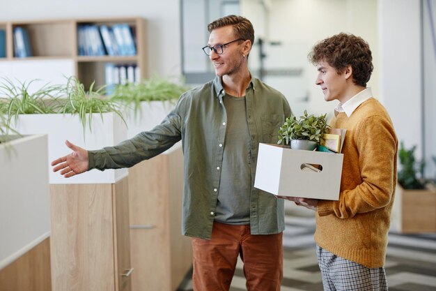 Mentor sorridente dando boas-vindas ao jovem no novo emprego