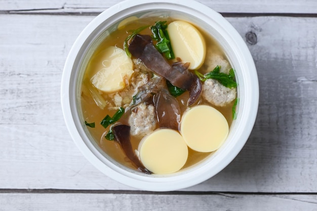 Menú comida sana sopa de tofu de huevo tazón de sopa transparente con champiñones de gelatina de cerdo sopa de vermicelli de verduras y hongos de gelatina negra