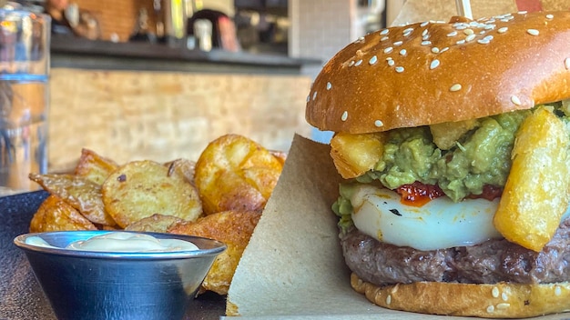 Menu completo de hambúrgueres com batatas estilo deluxe e molho branco servido em um restaurante