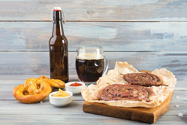 Foto menu de comida para o oktoberfest salsicha com diferentes molhos pretzel e um copo de cerveja escura