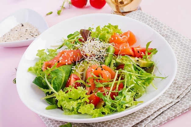 Menú de dieta Ensalada saludable de verduras frescas: tomates, aguacate, rúcula, semillas y salmón.