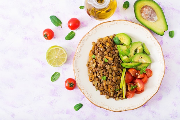 Menú de dieta Estilo de vida saludable. Gachas de lentejas y verduras frescas - tomates y aguacate